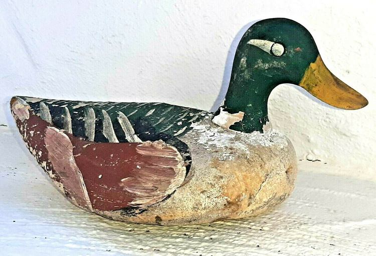 An antique duck decoy with some imperfections.