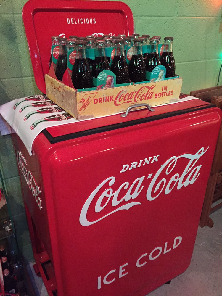 Coca Cola Christmas bottles atop original vintage Coca Cola ice chest