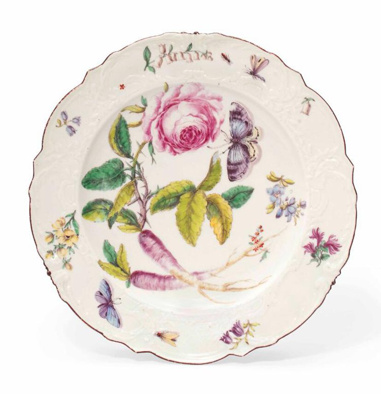 An old rimmed plate with design of flowers and fruits