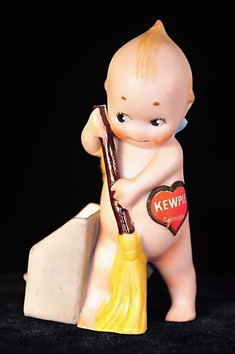 Small doll with a broom and a ‘Kewpie’ sticker